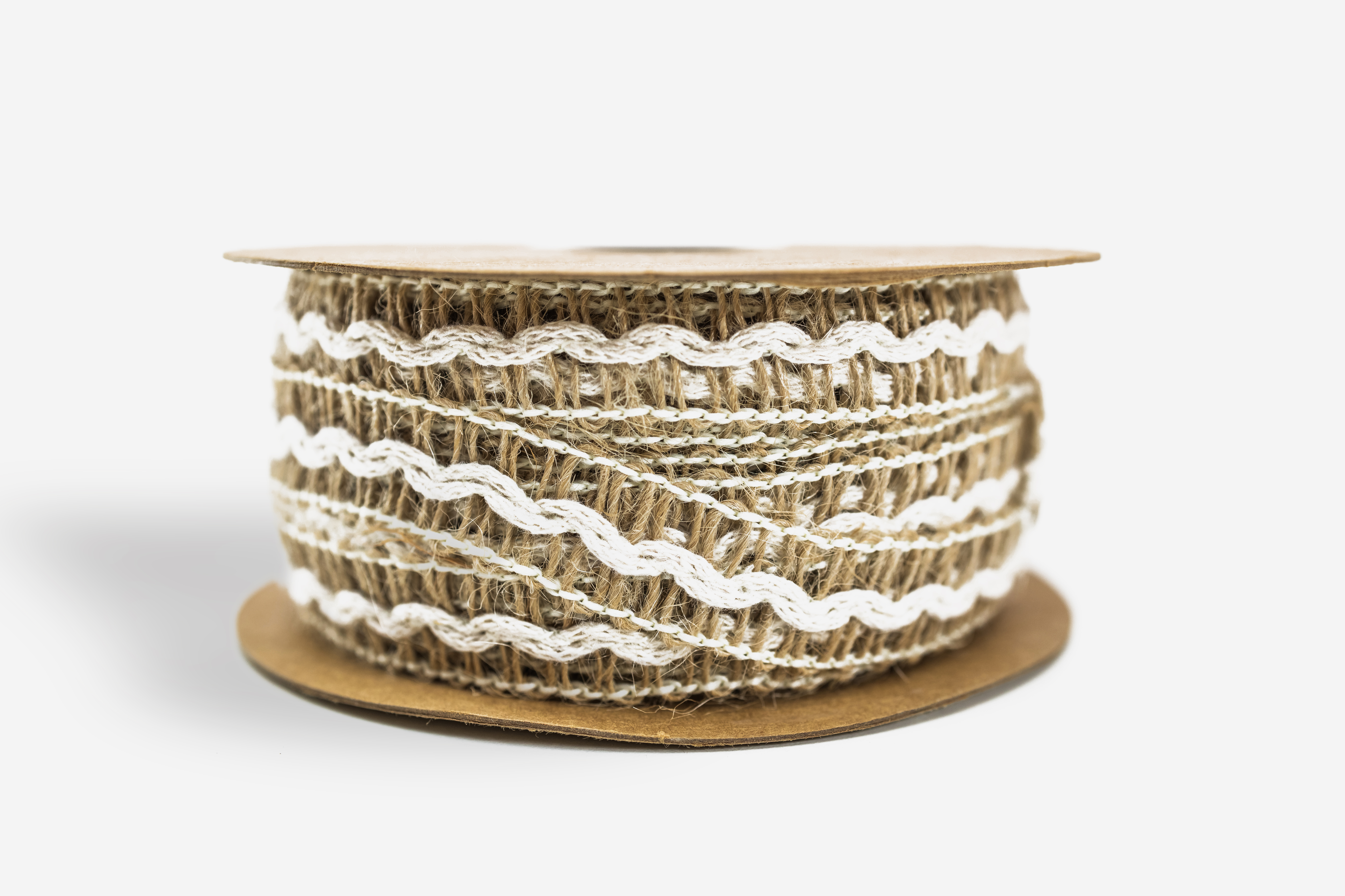 Detalle de cinta de tela blanca con bordado floral en relieve y calados tipo encaje, con bordes festoneados y textura suave, dispuesta en ondas elegantes sobre un fondo blanco satinado.