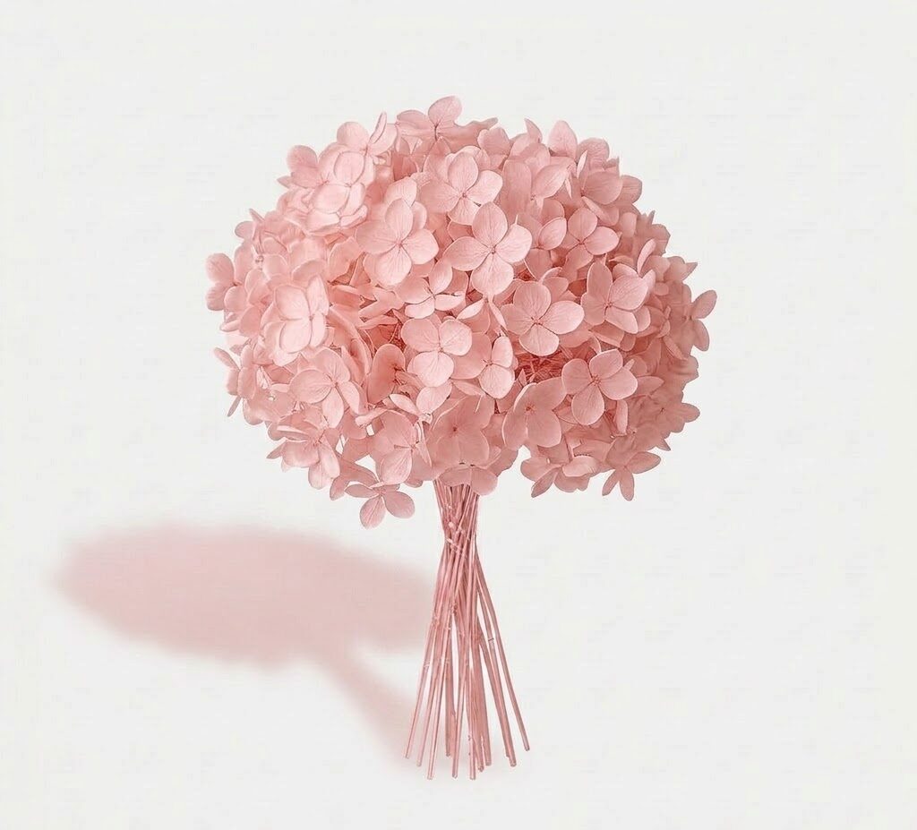 Gran ramillete de hortensia preservada rosa pastel de textura tersa, sobre fondo off-white con sombra suave.