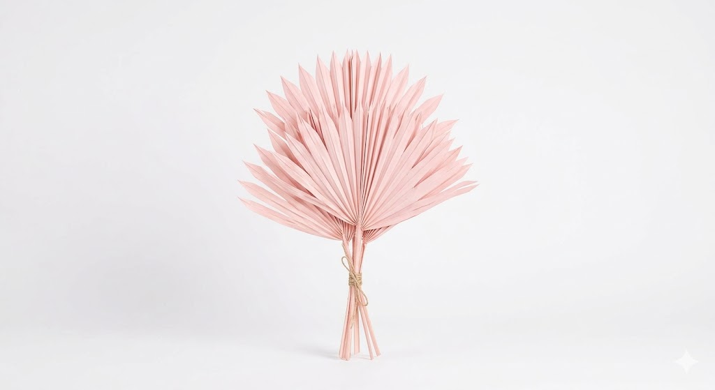 Una elegante hoja de Palm Spear deshidratada en un delicado tono rosa pastel, exhibiendo su corte simétrico en forma de lanza y su estructura plisada sobre un fondo blanco limpio.
