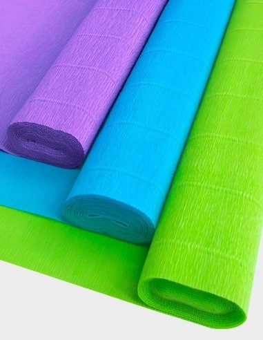 Pliegos de papel crepé de textura rugosa y elástica en tonos intensos, mostrando su característico rizado y flexibilidad junto a muestras de diferentes formatos y una amplia gama cromática.